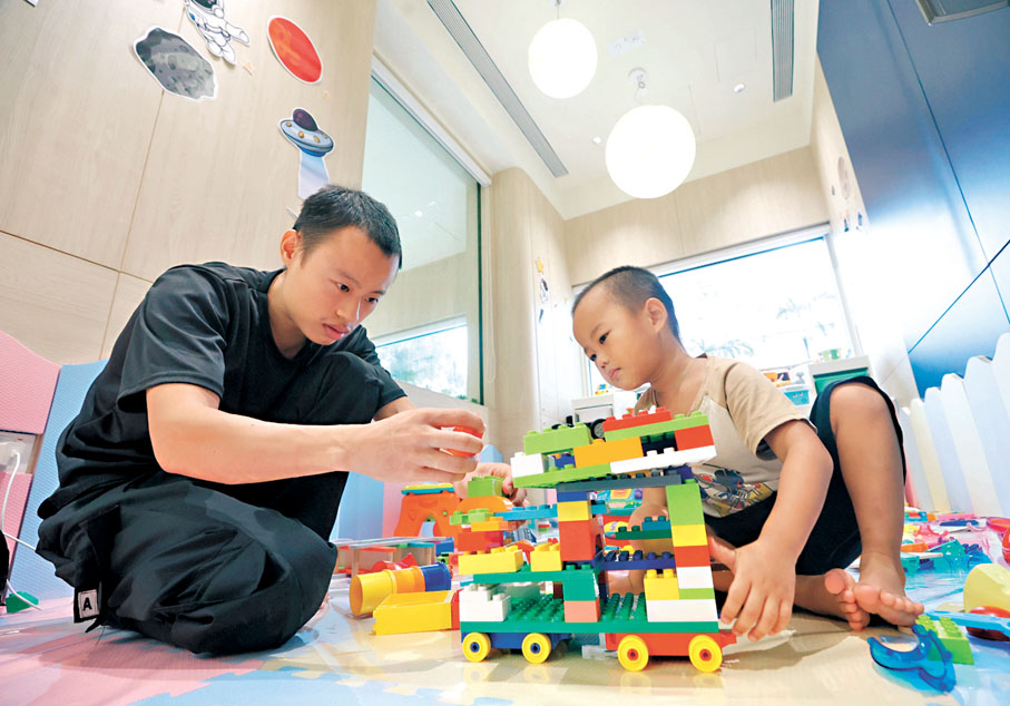 ●卓先生陪同兒子在社區客廳砌積木，兒子每天都說「要去客廳玩」。 香港文匯報記者郭木又  攝