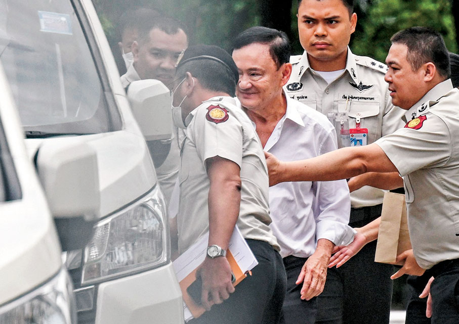 ●他信（中）步上囚車時面帶笑容。 法新社