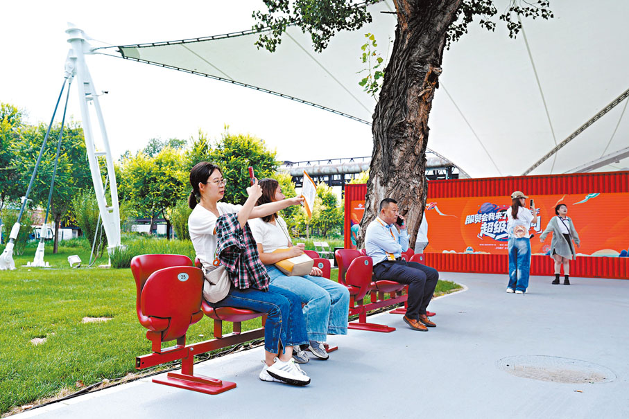●9月10日，在北京首鋼園舉行的2025年服貿會現場，天安門廣場閱兵時臨時觀禮台使用過的座椅吸引觀眾體驗。 中新社