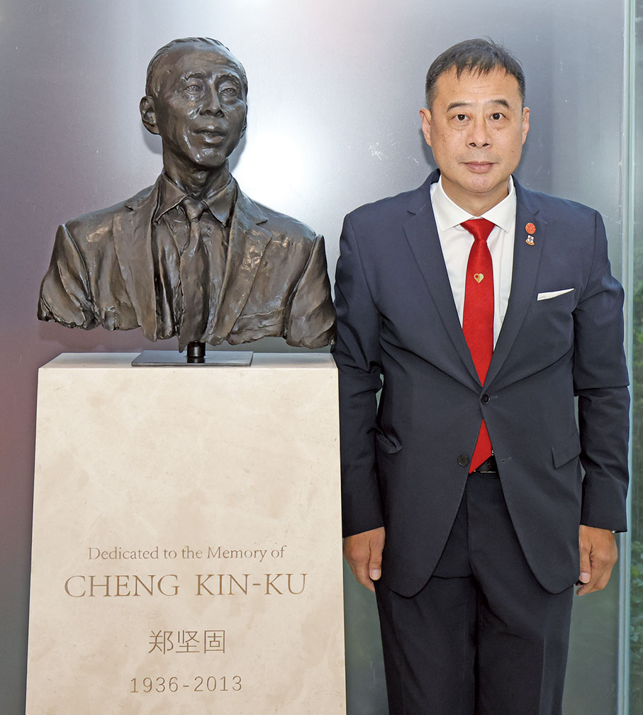 ●鄭建好與父親鄭堅固銅像合影。