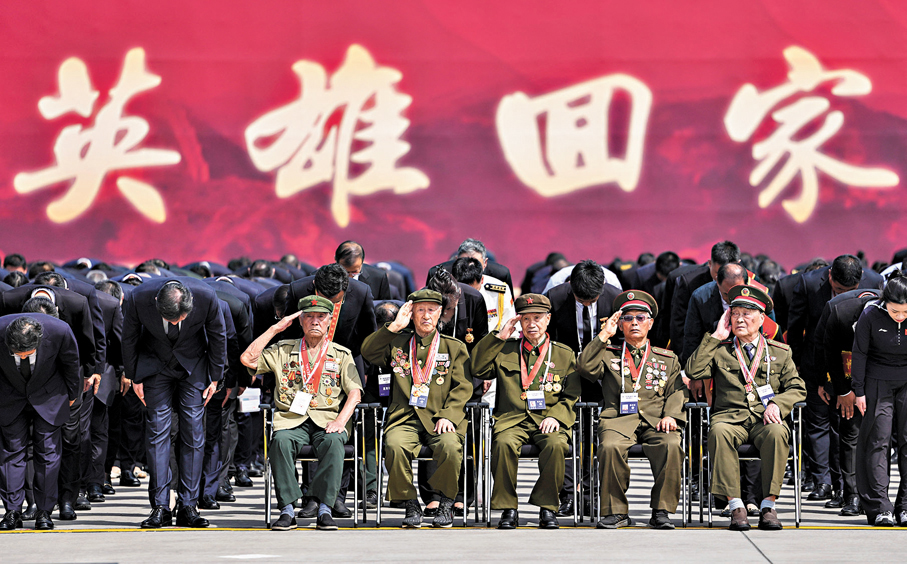 ●12日，志願軍老戰士在瀋陽桃仙國際機場舉行的迎回儀式上敬禮。 新華社