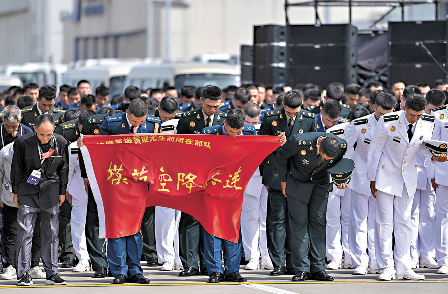 ●12日，在瀋陽桃仙國際機場，人們向志願軍烈士遺骸鞠躬。新華社