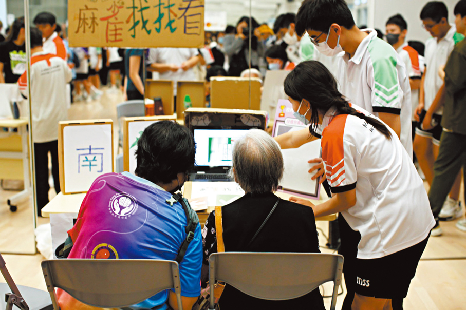 ●學生邀請附近腦退化長者及照顧者來學校玩攤位遊戲。 學校供圖