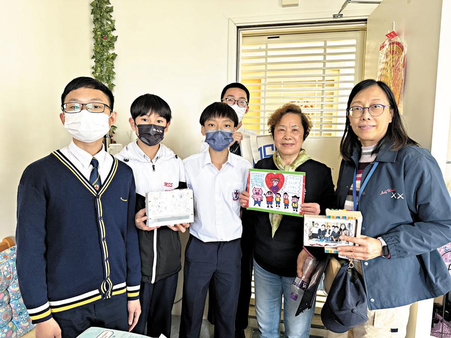 ●學生與安裝出門提示器的獨居長者合照。  學校供圖