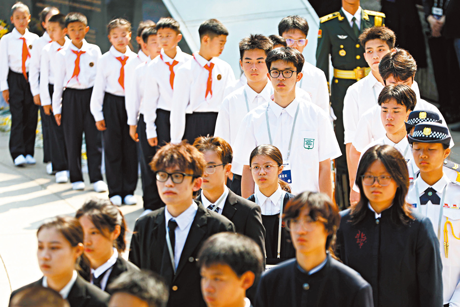 ●14名來自香港的中學生（白衣）在陵園英名牆前致敬英烈。