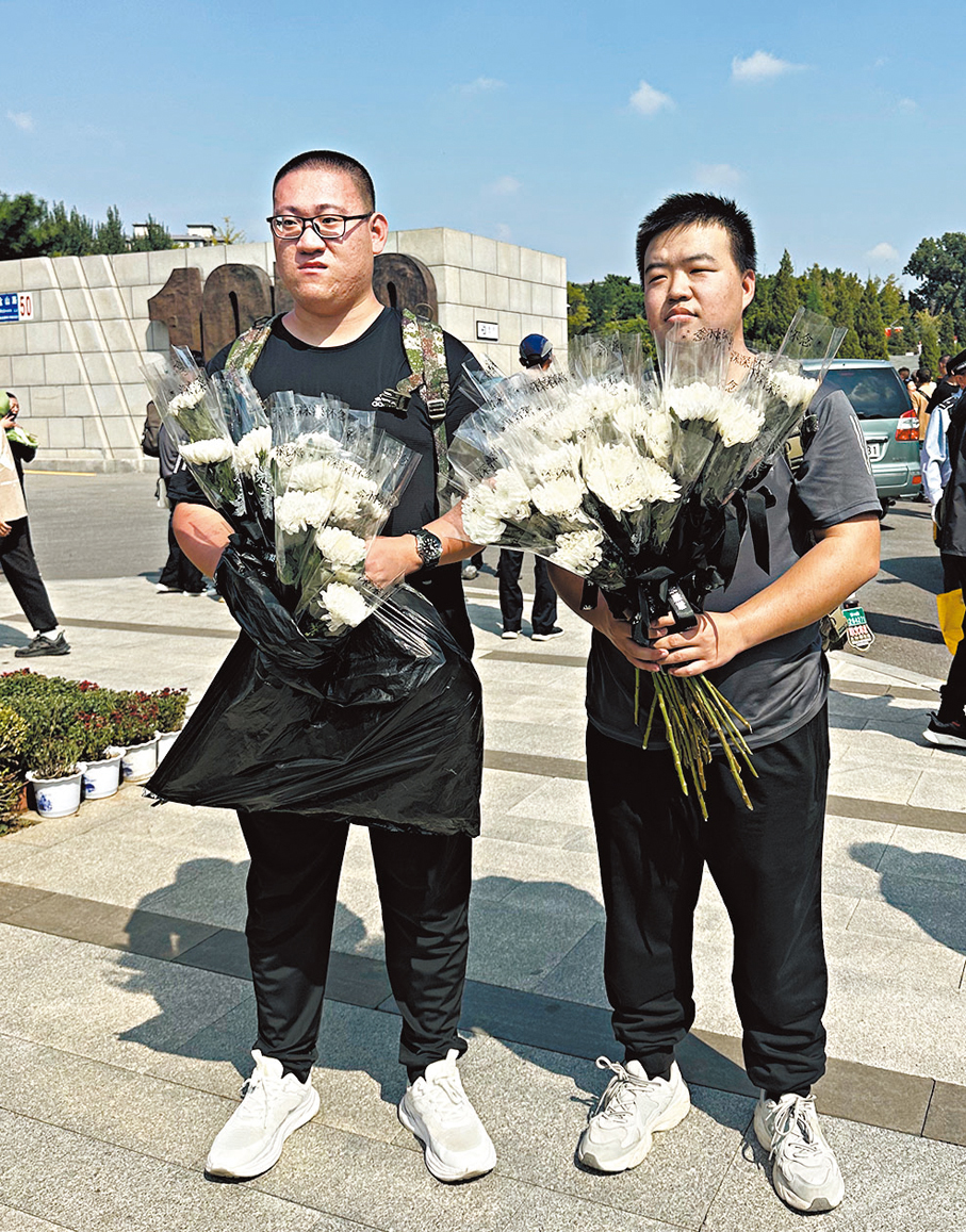 ●來自山西的青年梁斌斌與朋友手捧白菊來到烈士陵園祭奠先烈。
