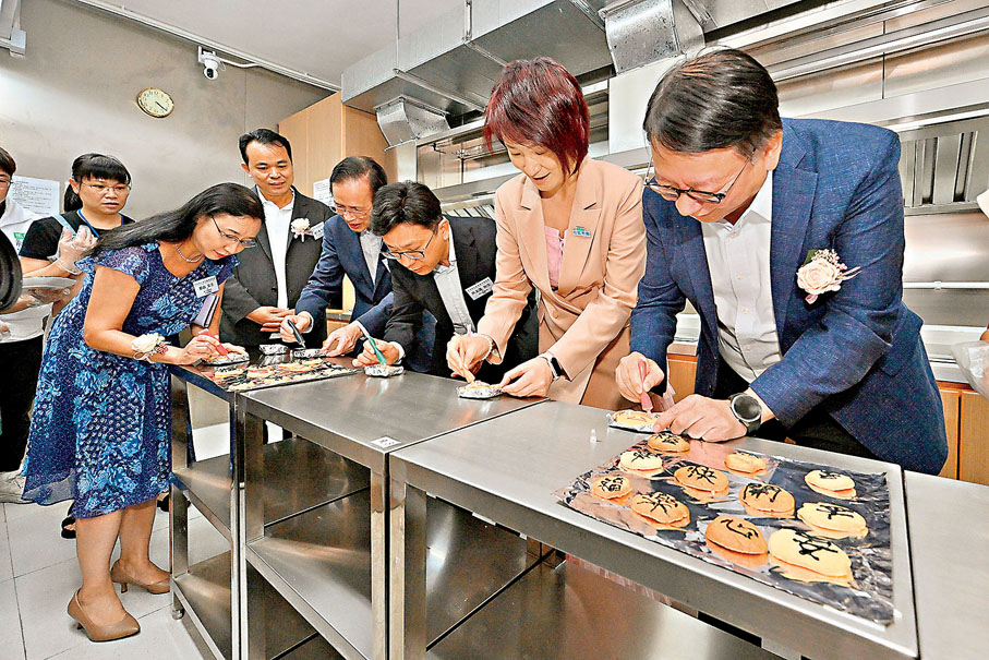 ●陳國基（右一）和孫玉菡（右三）等在共享煮食間與受惠家庭製作曲奇。