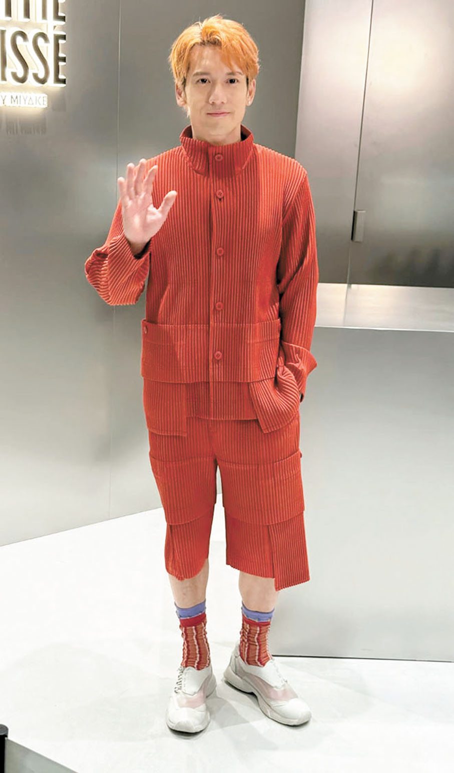 ●關智斌笑指自己的裝扮與橙色手提電話撞色。  香港文匯報記者梁靜儀  攝