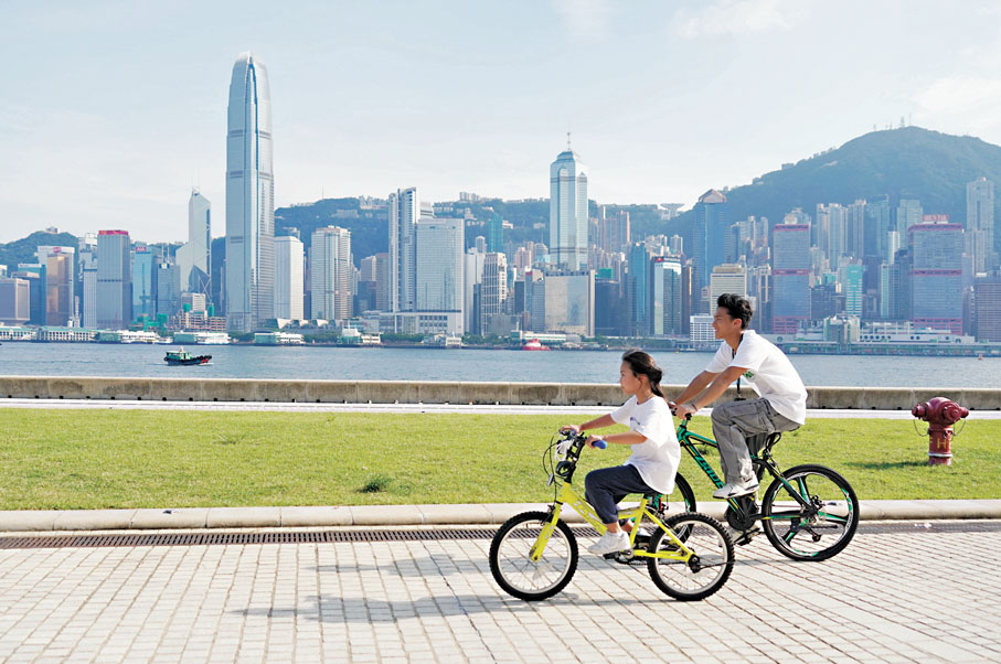 ●特首表示，施政報告採用綠色封面，代表政府政策和香港的繁榮活力會延續下來。圖為市民在西九龍文化區踏單車。 香港文匯報記者曾興偉  攝