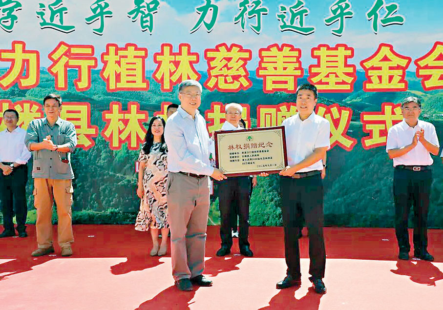 ●莊厚明醫生與石樓縣副縣長王國欽完成林權及樹木移交。