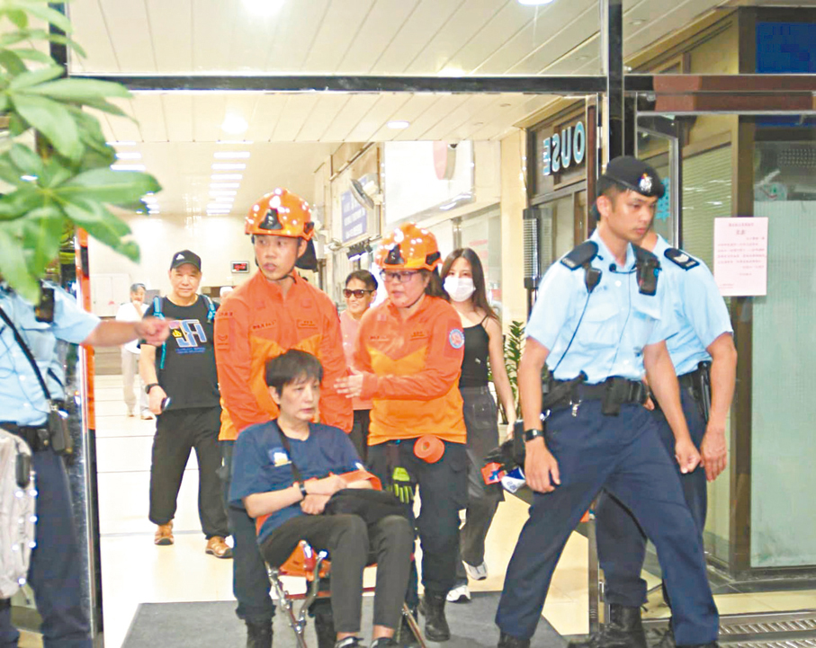●民安隊昨晚協助行動不便人士撤離。 香港文匯報記者鄺福強  攝