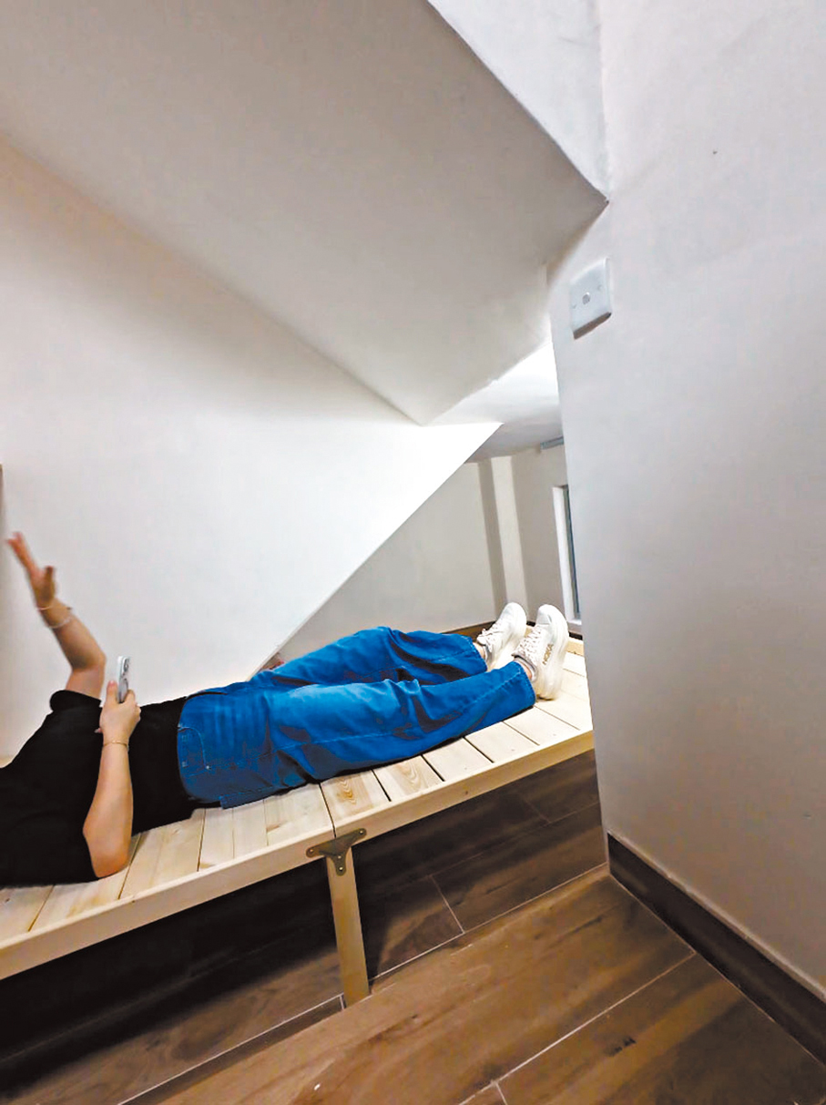 ●其中一間分間單位的床布置在樓梯下，記者親身體驗樓梯下的狹窄視角。香港文匯報記者黃宇威  攝