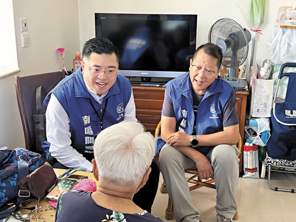 ●甄智健（左一）等隊員探訪獨居長者，協助長者做好應對颱風措施。 受訪者供圖