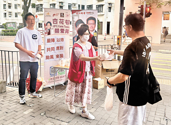 ●東區關愛隊（杏花）昨日向居民派發膠紙，協助居民應對颱風天氣。 受訪者供圖