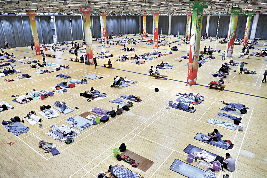 ●9月23日，在深圳大學粵海校區羽毛球館，避險群眾在場館內休息。   新華社