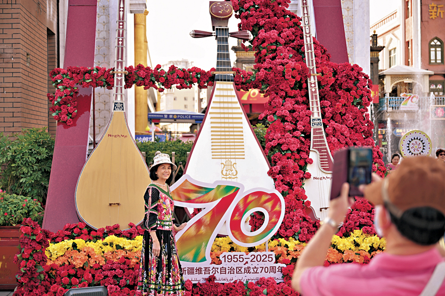 ●9月23日，遊客在新疆烏魯木齊市大巴扎步行街一處裝飾拍照留念。 中新社