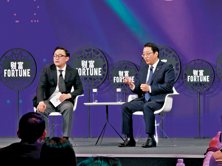 ●廣州汽車集團股份有限公司董事長馮興亞（右）分析汽車行業前景。 香港文匯報記者帥誠  攝