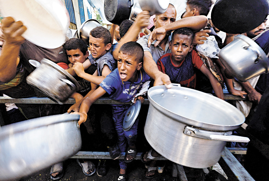 ●巴人聚集在加沙努塞拉特一家慈善廚房領取食物。路透社