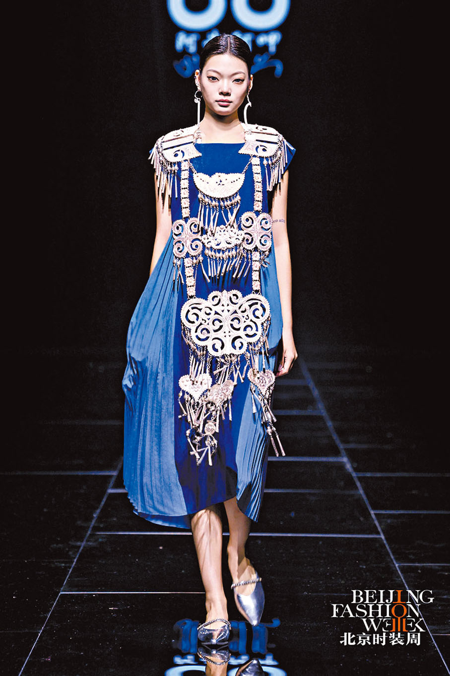 【第二篇章：錦繡共生】以蜀錦、蜀繡為核心，展現巴蜀文化的精緻與靈動。蜀錦織造技藝將代表着堅韌的生命力、團結與發展的彜族紋樣「蕨草紋」織造成本系列作品的面料，以蜀繡針法提升彜族工藝的精美度，蜀繡的細膩針法與彜族風格形成對比，卻又在色彩與結構上達成平衡，將傳統織錦與現代廓形結合，使千年技藝在當代時裝中流動。