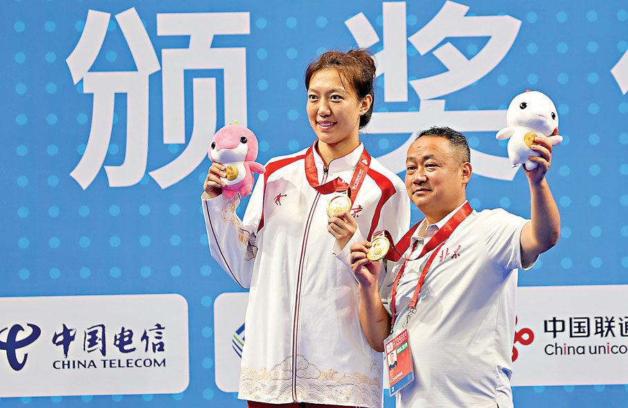 ●北京隊選手穆文喆（左）和教練在頒獎儀式上。 新華社