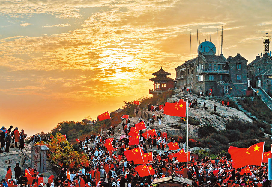 【泰山之巔】10月1日，萬名遊客齊聚泰山之巔，以升國旗、觀日出、唱愛國歌曲的方式，慶祝中華人民共和國成立76周年。 中新社