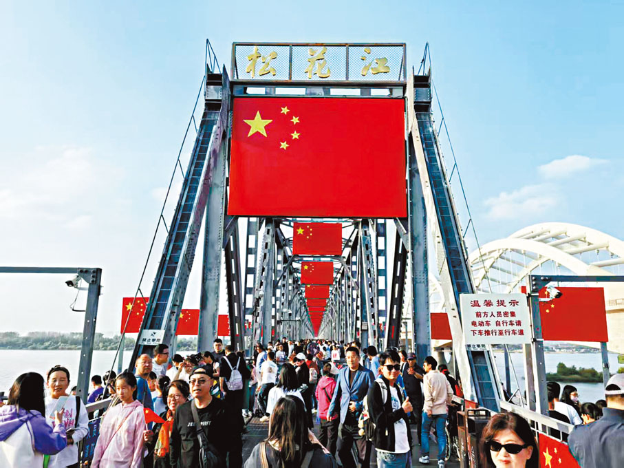 【哈爾濱】國慶假期首日，有120餘年歷史的黑龍江哈爾濱中東鐵路大橋懸掛起百餘面五星紅旗，吸引全國各地遊客。 香港文匯報記者于海江 攝