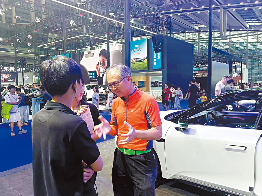 ●港人黎先生（右一）前來領克展館諮詢購車。香港文匯報記者李昌鴻  攝