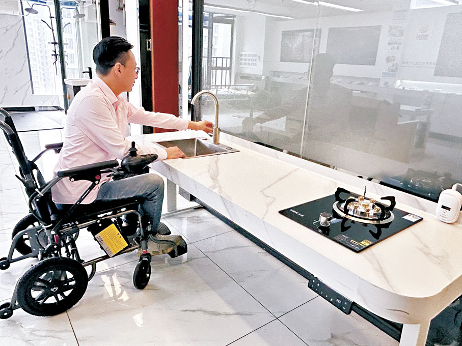 ●梁子斌體驗展示「粵安芯」團隊開發的可升降智能灶台。 香港文匯報記者敖敏輝  攝