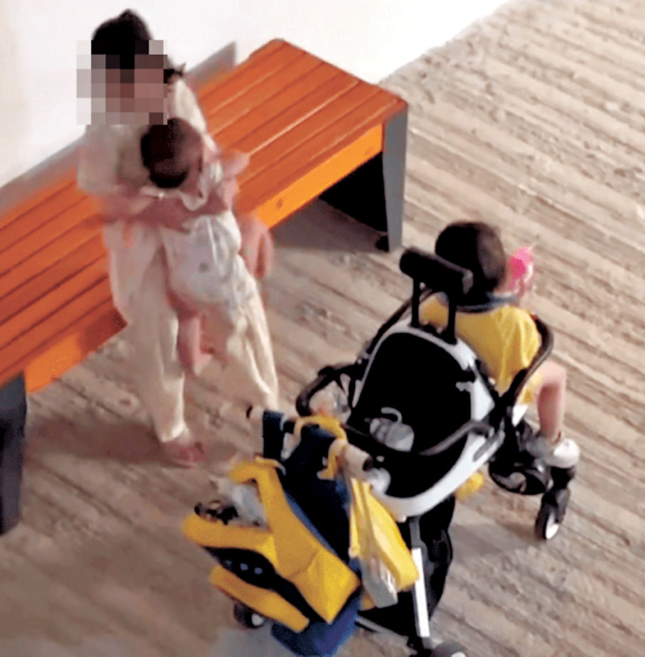 ●涉案女童再度抱起女嬰。