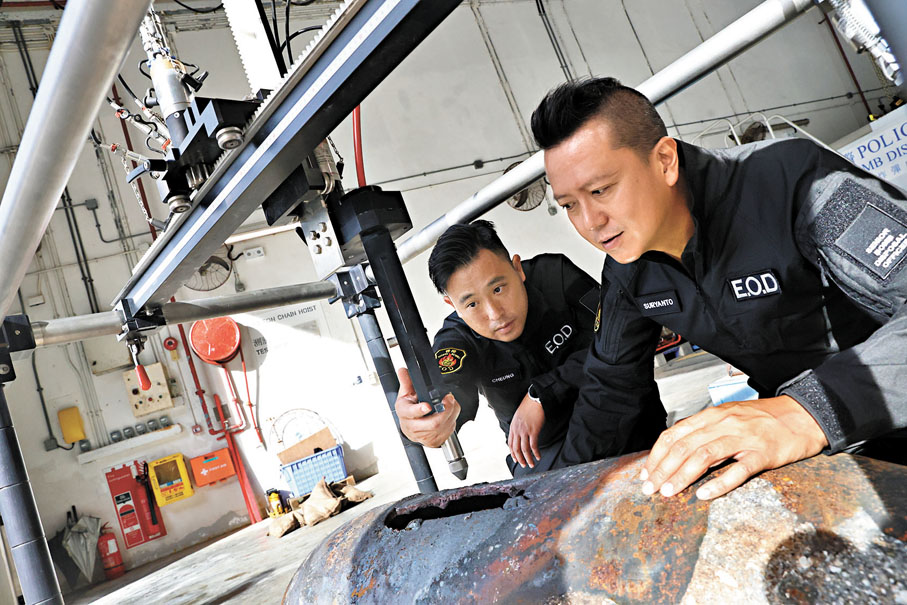 ●左起：張立得與李展超檢查上月在鰂魚涌發現的美軍空投炸彈。 香港文匯報記者萬霜靈 攝