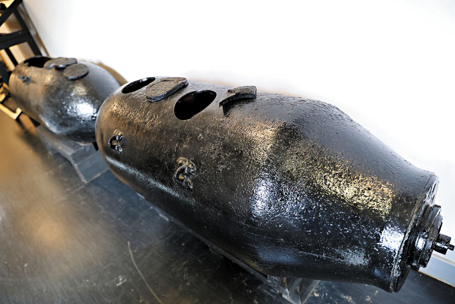 ●2014年在跑馬地一個地盤發現的一枚1,000磅美軍空投炸彈，後方是2018年沙中線地盤發現的一枚美軍空投炸彈。 香港文匯報記者萬霜靈  攝