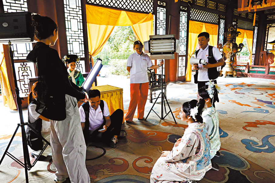 ●10月1日，在浙江東陽橫店影視城，遊客組團體驗影視拍攝。圖為遊客（右側古裝者）體驗演戲。 中新社
