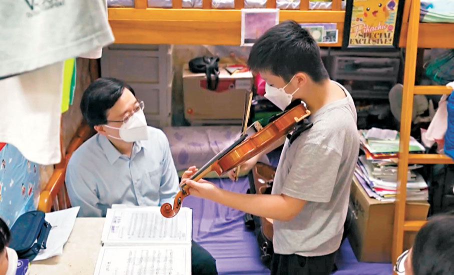 ●2022年中，將升讀中二的李靖甫在家裏為上任1個月的特首李家超演奏一曲小提琴。李家超Fb片段截圖