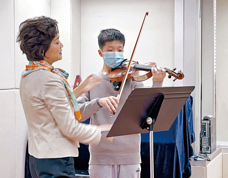 ●姚珏（左）指導李靖甫拉琴的指法，而靖甫亦透過不斷的訓練增加了自信心。資料圖片