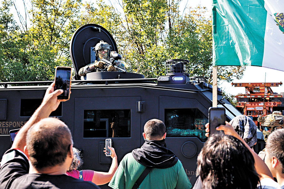 ●ICE人員在車上向示威者擎槍。美聯社