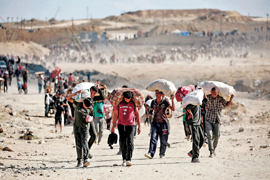 ●大批巴人提着袋子，離開加沙中部一個食物分發點。 法新社