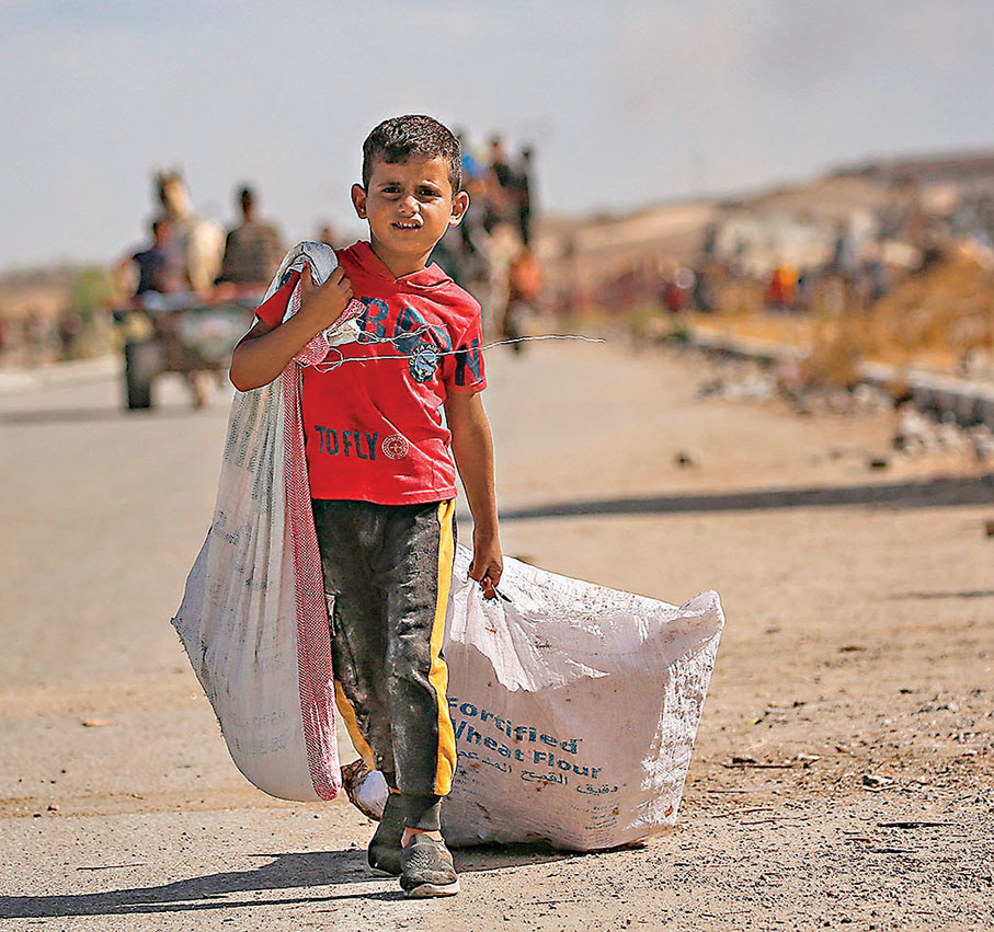 ●一名流離失所的巴童在加沙撤離。 法新社