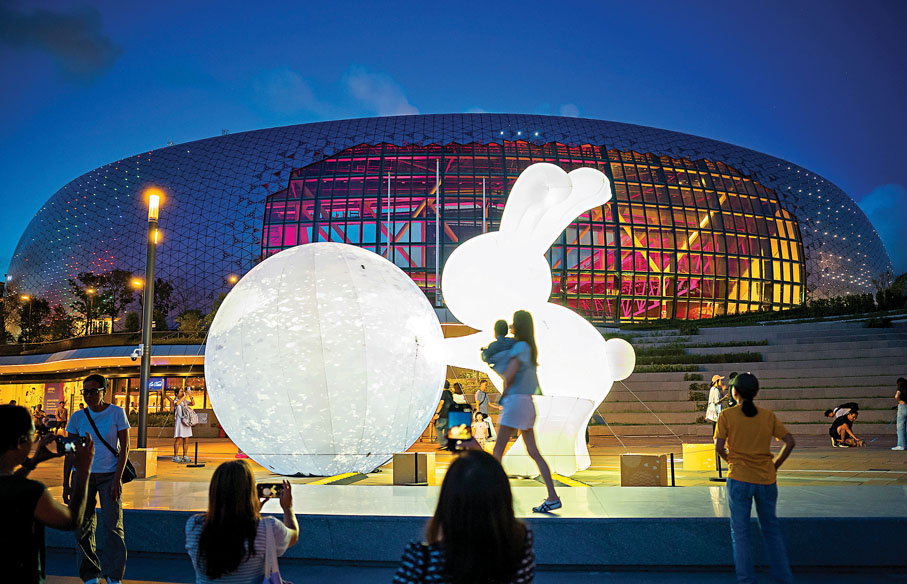 ●昨日香港市民在啟德體育園主場館前欣賞綵燈。    中新社