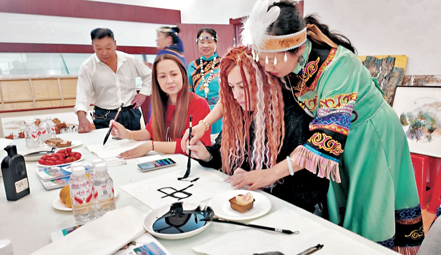 ●中國民眾手把手教俄羅斯遊客寫書法。香港文匯報黑龍江傳真