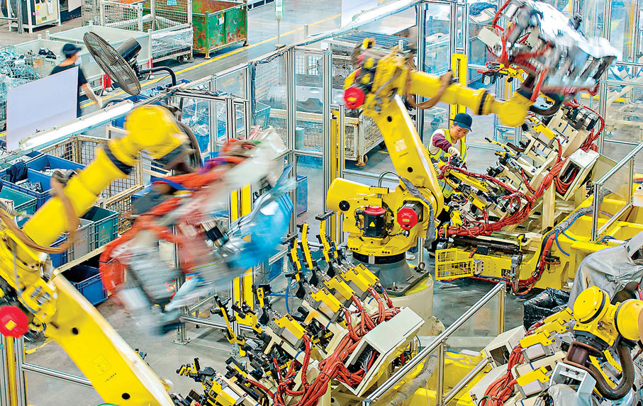 ●國家已實施十四個五年規劃，實現了從站起來、富起來到強起來的偉大飛躍。圖為技術人員在操控工業機器人生產新能源汽車配件。  新華社