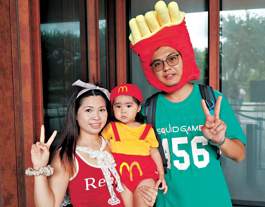 ●戴上麥當勞薯條造型頭套的莫先生（右）。香港文匯報記者黃艾力  攝