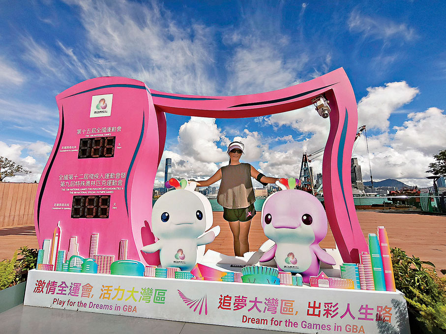 ●圖為市民在添馬公園設置的全運會倒計時牌留影。中通社