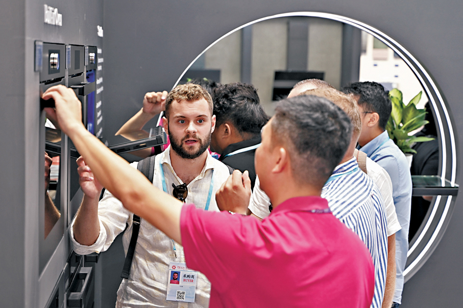 ●15日，第138屆中國進出口商品交易會在廣州開幕。圖為廣交會採購商在家用電器展區挑選產品。 中新社