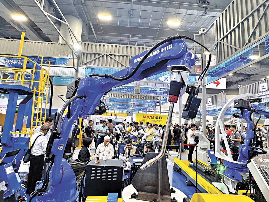 ●一外貿企業將大型機械設備搬到廣交會，來自新興國家的採購商正在了解產品信息。香港文匯報記者盧靜怡  攝