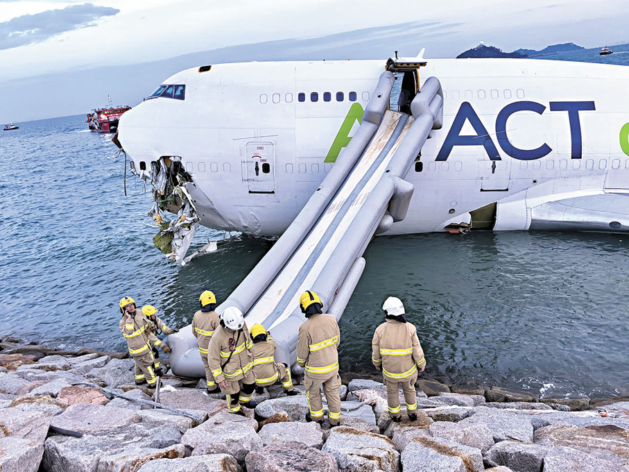 ●消防人員透過逃生滑梯協助貨機4名機組人員離開機艙。 消防處供圖