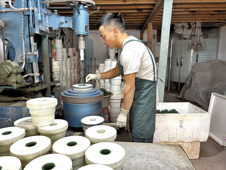 ●潛洛村「夢涵紫砂」工坊裏，小范操作輥壓機生產「機車杯」。香港文匯報記者陳旻  攝