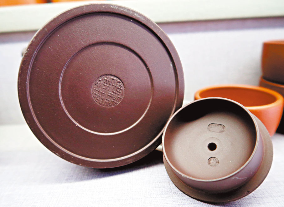 ●內壁章曾為手工壺的標識，但產自潛洛村的紫砂「機車壺」，壺底印章與壺蓋內壁章齊全。 香港文匯報記者陳旻  攝