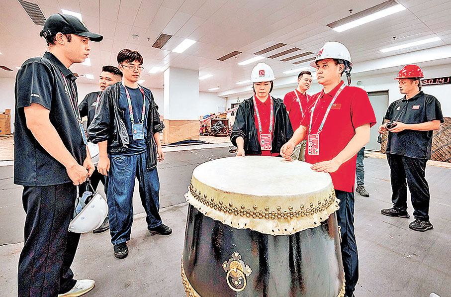 ●王銳祥（右二）在和團隊檢查開幕式舞台道具。