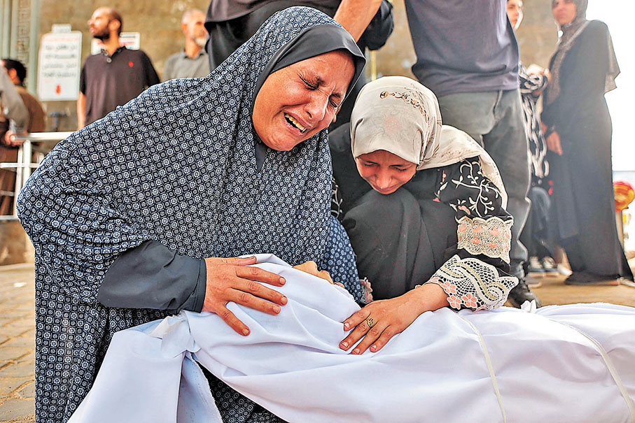 ●在加沙城希法醫院，巴人在遇難家屬遺體旁哭泣。 法新社