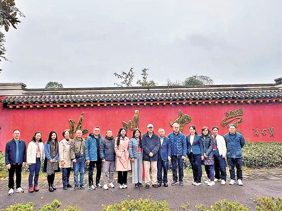 ●劉亞春校長（右六）與我們在新北川中學校門口外牆合影。 作者供圖